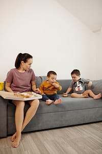 Mom and kids eating pizza on the couch