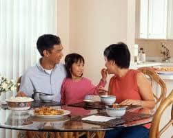 Young girl eating dinner with her parents
