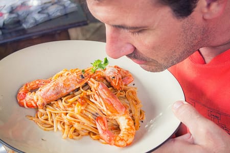 A man smells his dinner before eating it.