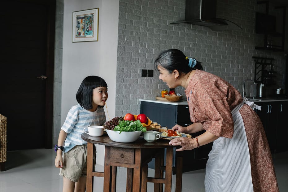 happy woman with little girl preparing healthy lunch